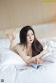 A woman laying on a bed reading a book.