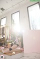 A woman sitting on the floor in front of a pink box.