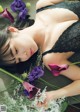 A woman laying on the ground with a bunch of flowers.