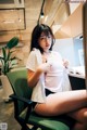 A woman sitting on a green chair in an office.